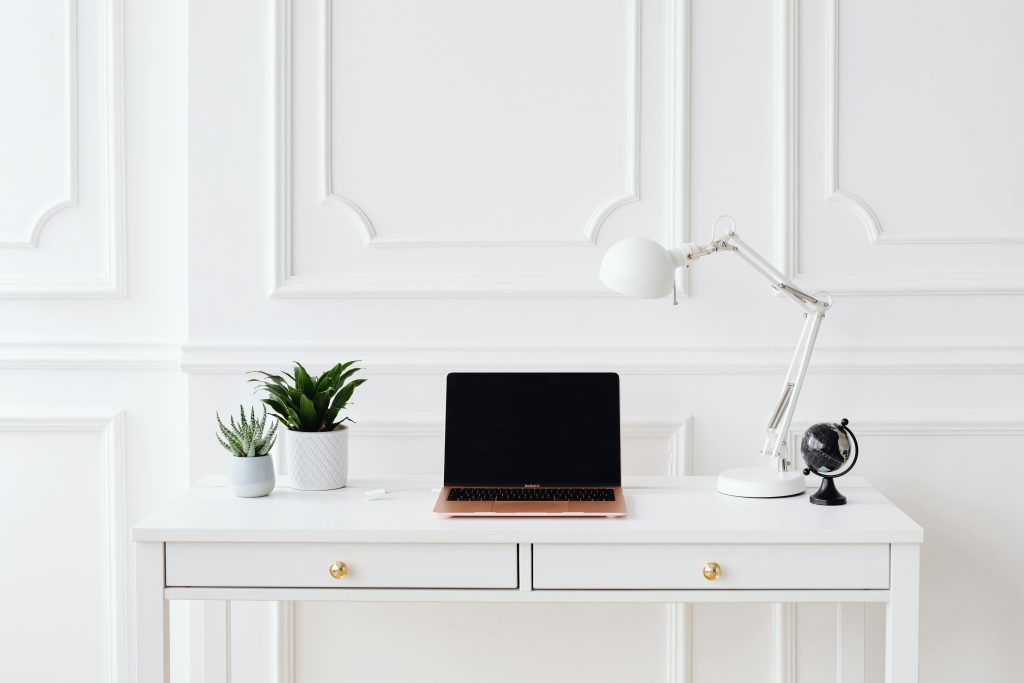 pexels photo 8092309 8092309 A minimalist home office setup featuring a laptop on a white desk with decor items.